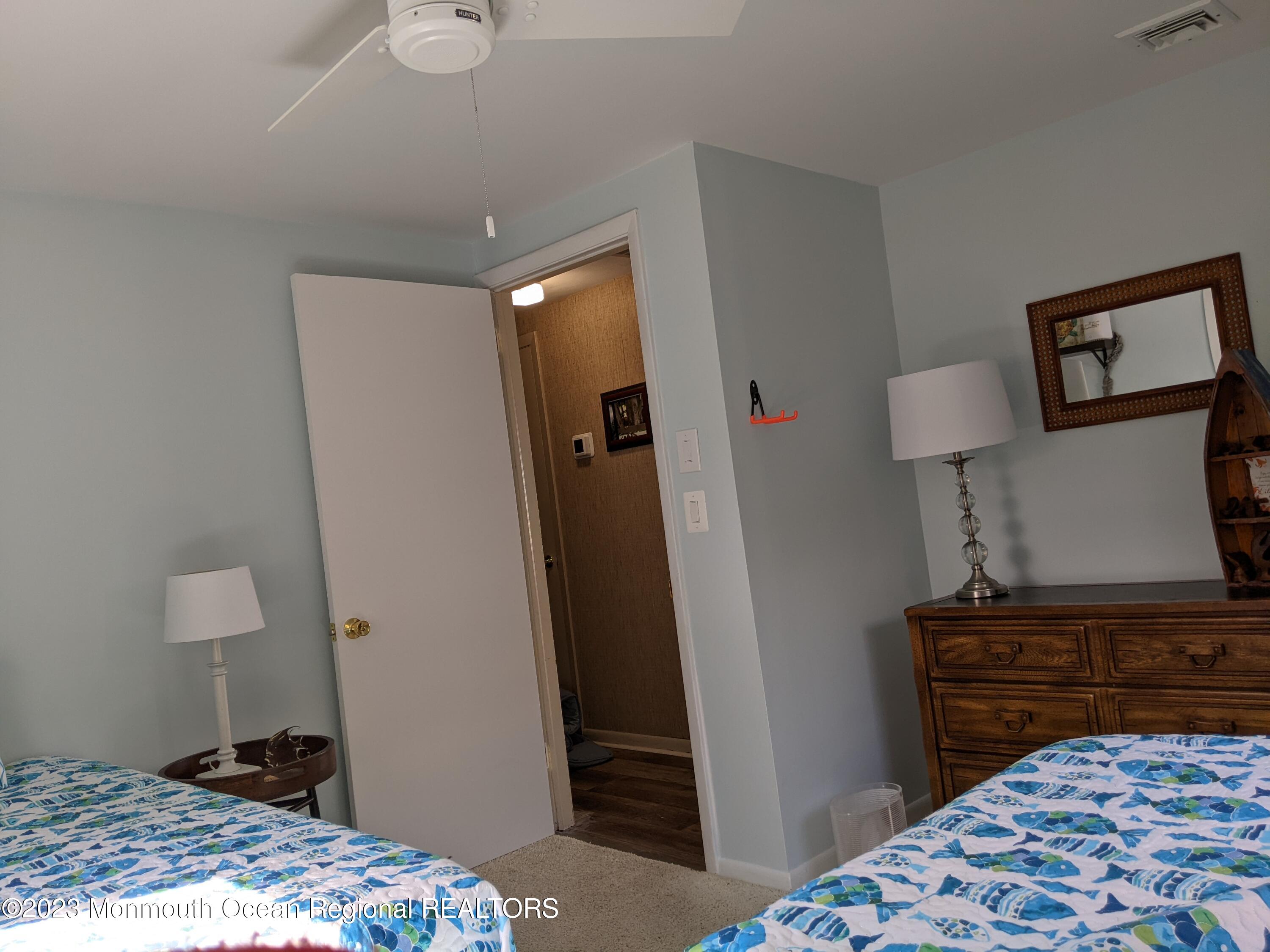 289 Monterey Circle Lavallette, NJ 08735 - Photo 11 of 32 a bedroom with a bed and a lamp on dresser
