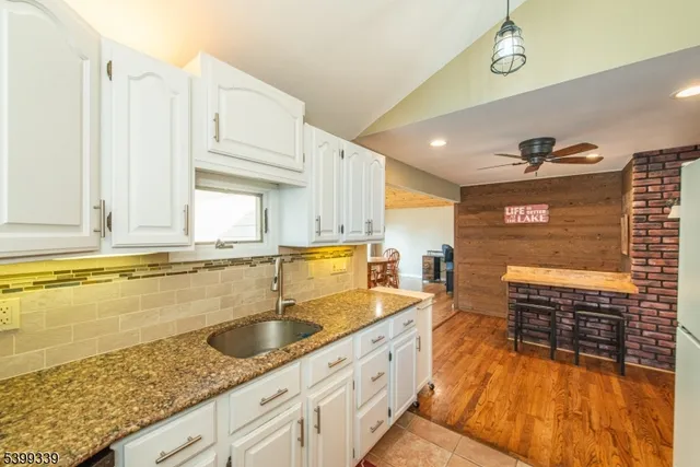 a kitchen with stainless steel appliances granite countertop a sink stove and cabinets