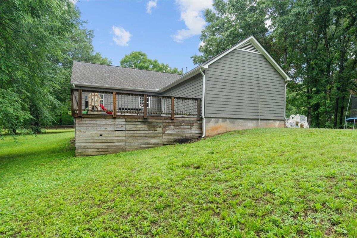 150 Liberty Road Moscow, TN 38057 - Photo 27 of 36 Rear exterior featuring a spacious wooden deck with railings, grey horizontal siding, and a gabled roofline