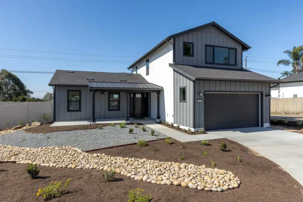 a front view of a house with a garden and patio