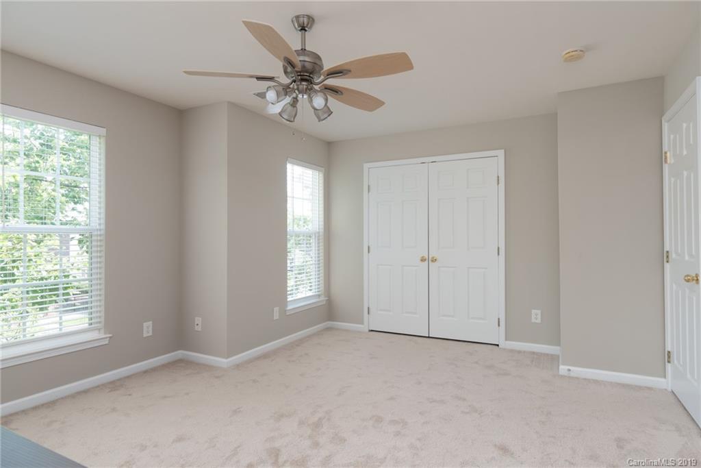 4854 Prosperity Ridge Road Charlotte, NC 28269 - Photo 16 of 22 an empty room with chandelier fan and windows