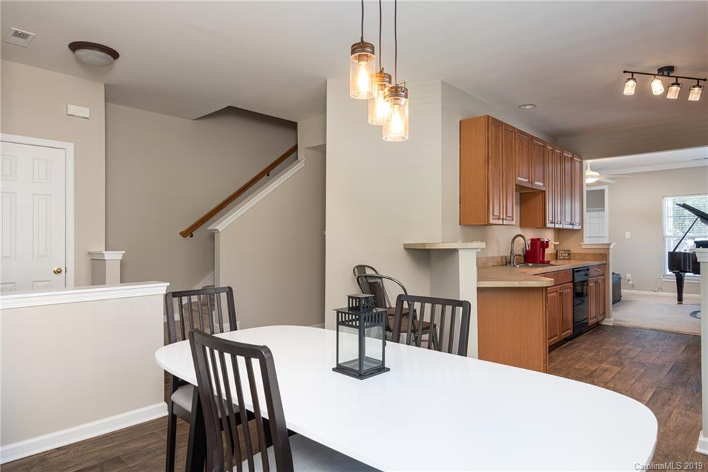 4854 Prosperity Ridge Road Charlotte, NC 28269 - Photo 7 of 22 a kitchen with stainless steel appliances a dining table chairs and chandelier