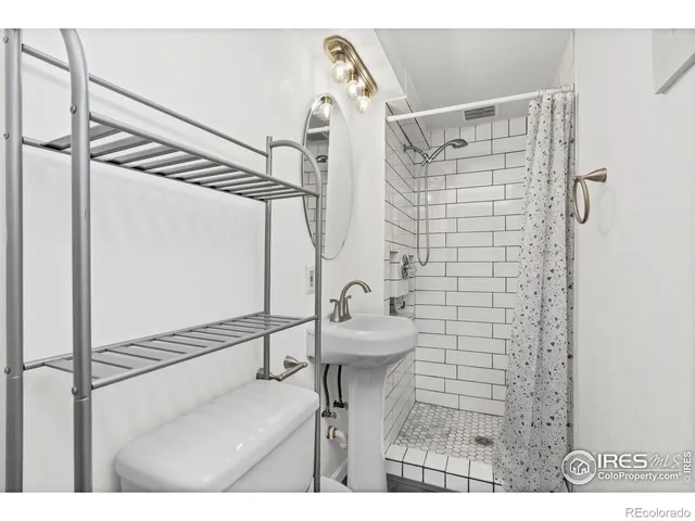 a bathroom with a sink mirror and a shower