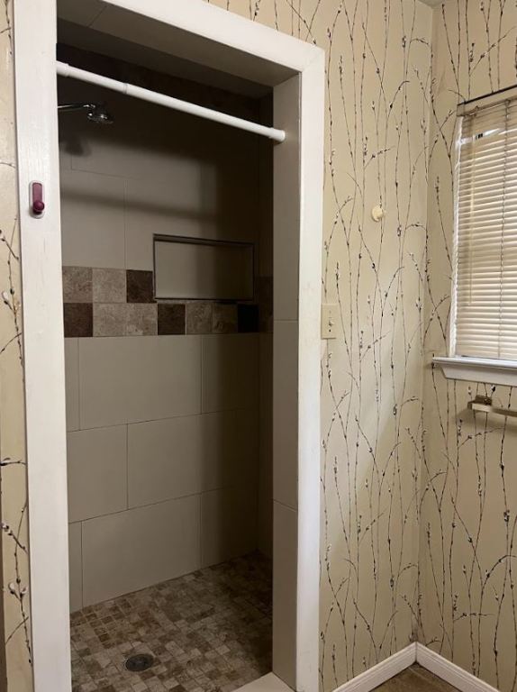 2813 1/2 Rio Grande Street, Unit 5 Austin, TX 78701 - Photo 17 of 21 Bathroom with wallpapered walls and a shower stall