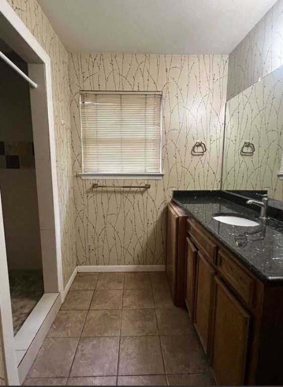 2813 1/2 Rio Grande Street, Unit 5 Austin, TX 78701 - Photo 18 of 21 Full bath with vanity, wallpapered walls, light tile patterned flooring, and a stall shower