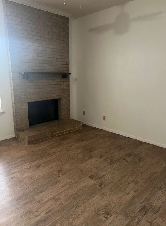 2813 1/2 Rio Grande Street, Unit 5 Austin, TX 78701 - Photo 2 of 21 Unfurnished living room featuring a brick fireplace and dark wood finished floors