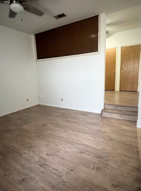 2813 1/2 Rio Grande Street, Unit 5 Austin, TX 78701 - Photo 3 of 21 Empty room with wood finished floors and ceiling fan