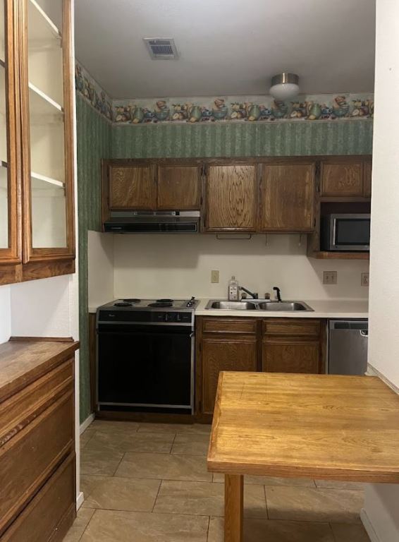 2813 1/2 Rio Grande Street, Unit 5 Austin, TX 78701 - Photo 6 of 21 Kitchen with appliances with stainless steel finishes, glass insert cabinets, extractor fan, and light countertops