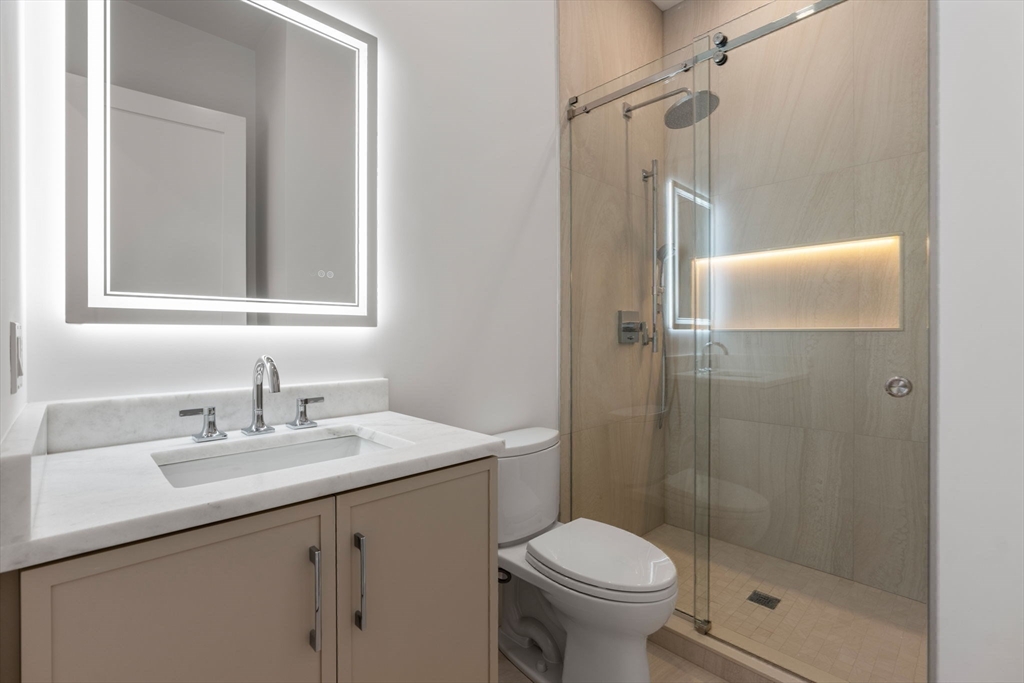 470 Quinobequin Road Newton, MA 02468 - Photo 26 of 37 a bathroom with a shower sink vanity mirror and toilet