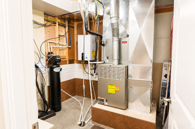 1055 North 1000 East Mapleton, UT 84664 - Photo 51 of 112 Utility area featuring a water softener, tankless water heater, and forced-air furnace