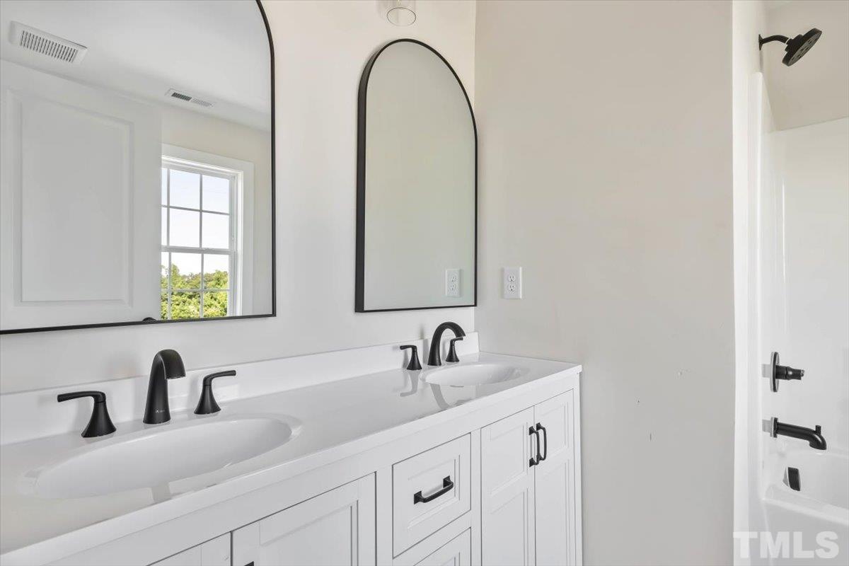 2075 Highway 55 Coats, NC 27521 - Photo 20 of 24 a bathroom with a double vanity sink and a mirror