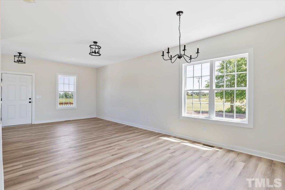 2075 Highway 55 Coats, NC 27521 - Photo 7 of 24 an empty room with wooden floor windows and ceiling fan