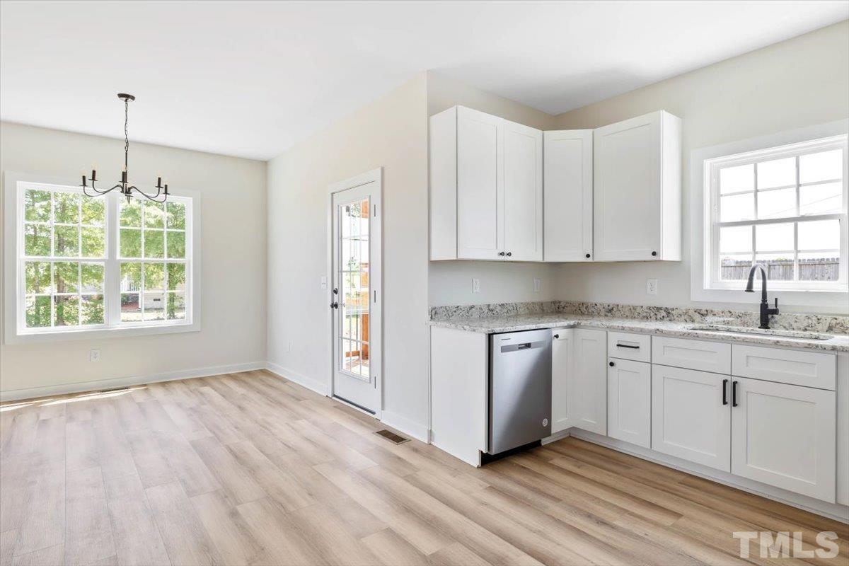 2075 Highway 55 Coats, NC 27521 - Photo 8 of 24 a kitchen with granite countertop white cabinets and window