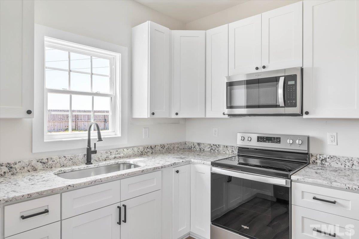 2075 Highway 55 Coats, NC 27521 - Photo 9 of 24 a kitchen with granite countertop white cabinets and a sink
