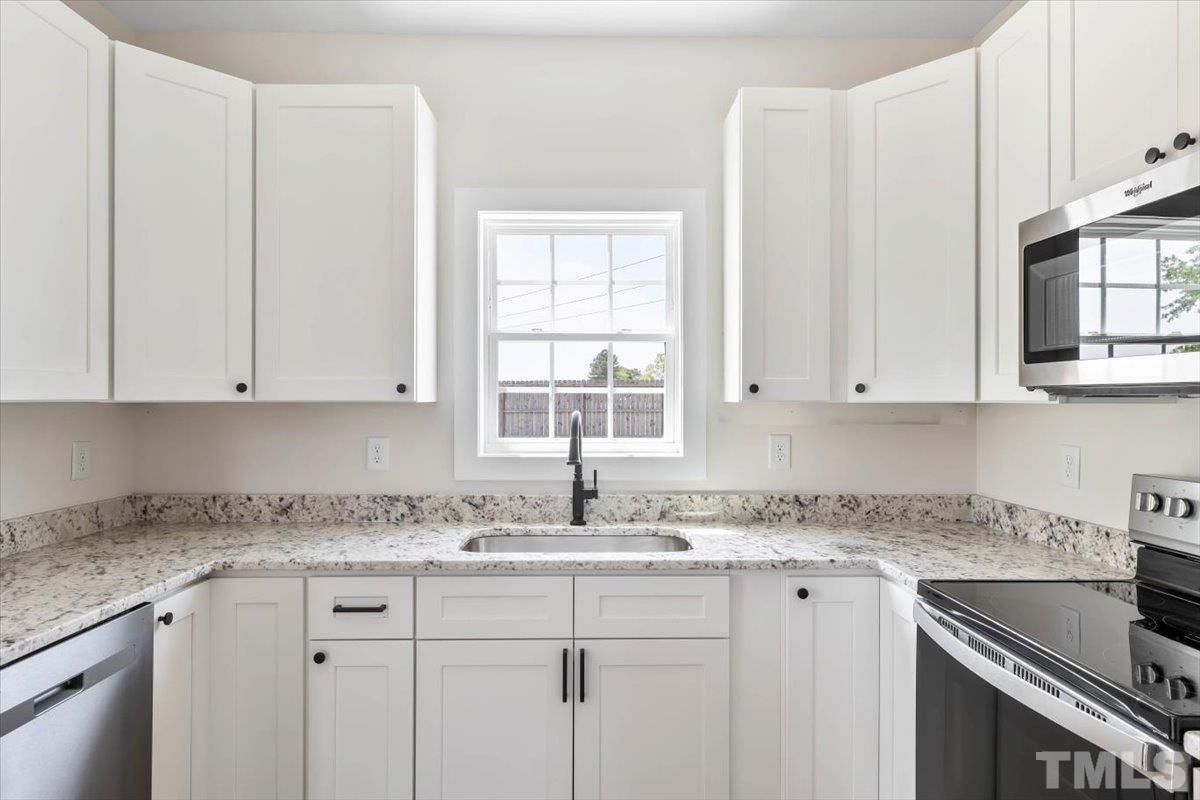 2075 Highway 55 Coats, NC 27521 - Photo 10 of 24 a kitchen with granite countertop white cabinets sink and window