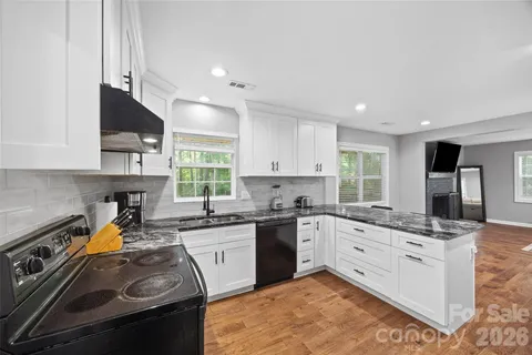 a kitchen with a sink stove top oven and cabinets