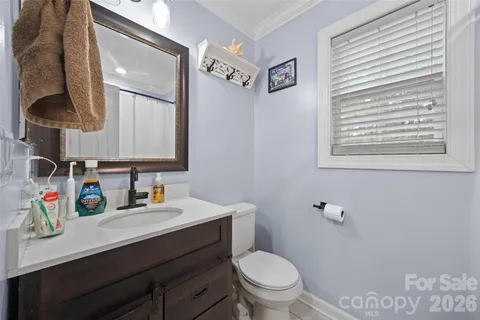 a bathroom with a toilet sink double vanity and mirror