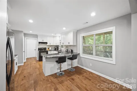 a kitchen with a sink appliances cabinets and dining table