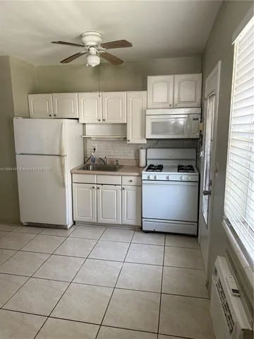a kitchen with a stove cabinets and a refrigerator