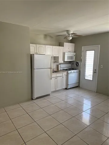 a kitchen with granite countertop a refrigerator and a stove top oven