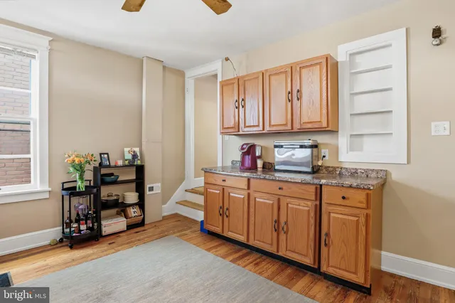 a kitchen with granite countertop a refrigerator and cabinets