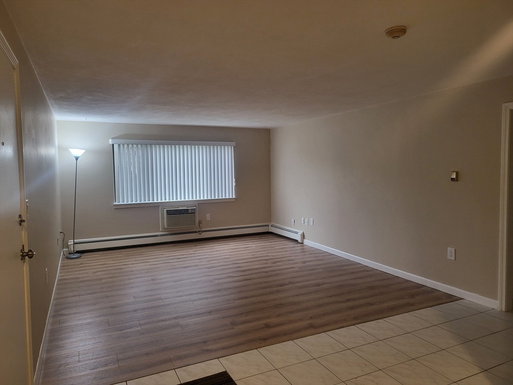 1 Hallmark Gardens, Unit 1 Burlington, MA 01803 - Photo 7 of 14 an empty room with wooden floor and windows