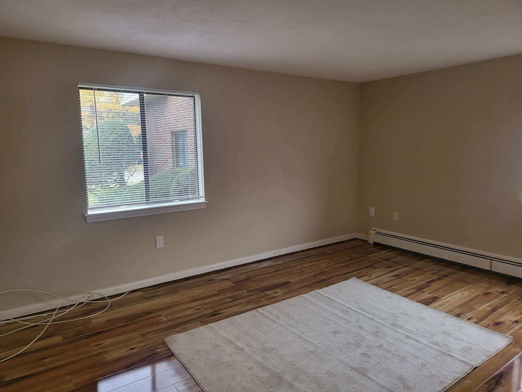 1 Hallmark Gardens, Unit 1 Burlington, MA 01803 - Photo 9 of 14 an empty room with wooden floor and windows