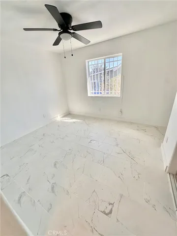 a view of a livingroom with a ceiling fan and window