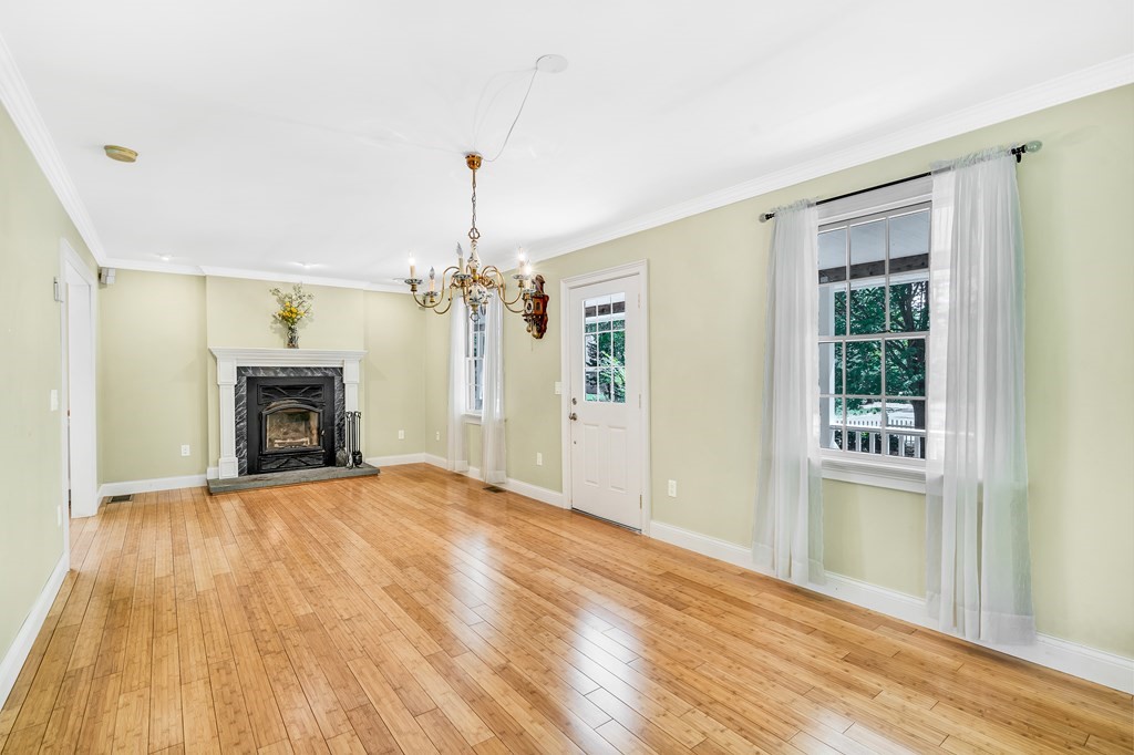 236 Gates Pond Road Berlin, MA 01503 - Photo 8 of 42 a view of an empty room with wooden floor fireplace and a window