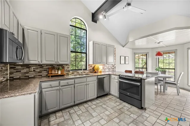 a kitchen with stainless steel appliances granite countertop a sink and cabinets