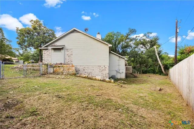 a view of backyard of house and car parked