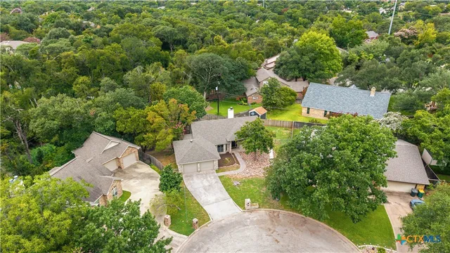 an aerial view of a house with a yard and trees