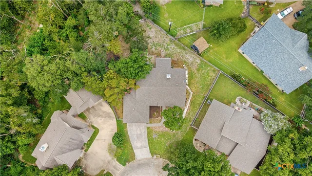 an aerial view of a house with a garden and trees