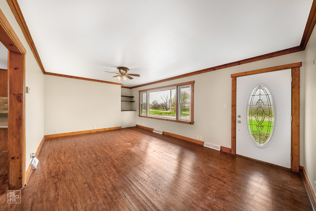 25915 South Tehle Road Elwood, IL 60421 - Photo 3 of 15 an empty room with wooden floor and windows
