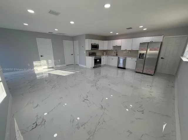 a view of kitchen with refrigerator and wooden floor