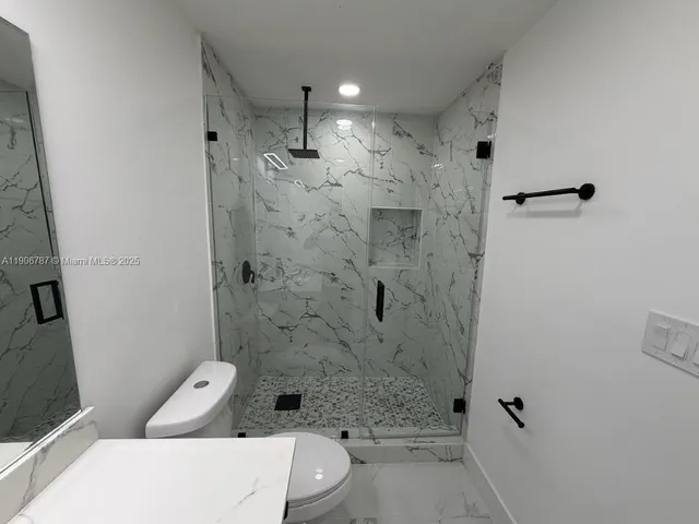 a bathroom with a toilet a sink and shower