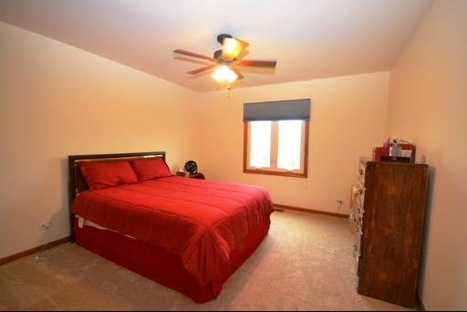 1860 Lisson Road Naperville, IL 60565 - Photo 14 of 16 a bedroom with a bed and a chandelier
