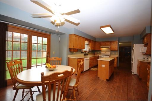 1860 Lisson Road Naperville, IL 60565 - Photo 5 of 16 a kitchen with stainless steel appliances kitchen island granite countertop a stove a refrigerator a oven a dining table and chairs with wooden floor