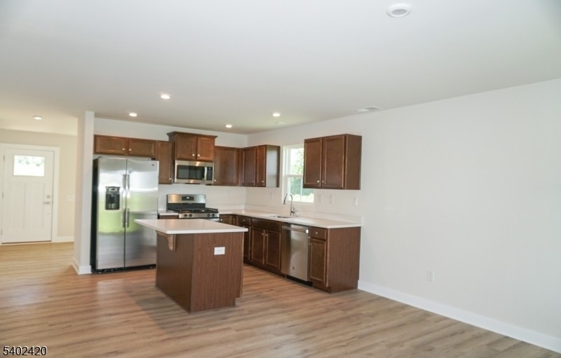 60 Coventry Road Hamburg, NJ 07419 - Photo 8 of 15 a kitchen with stainless steel appliances granite countertop a stove top oven a sink dishwasher and a refrigerator with wooden floor