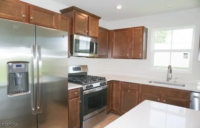a kitchen with stainless steel appliances granite countertop a refrigerator and a sink