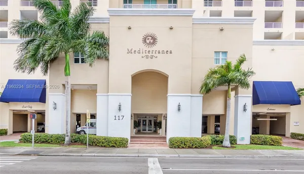 a front view of a building with garden and plants