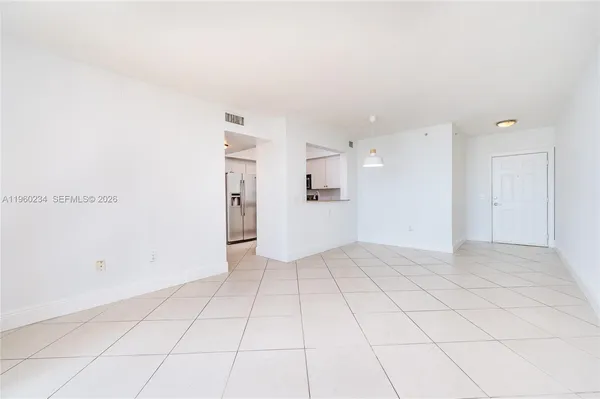 a view of an empty room with a kitchen