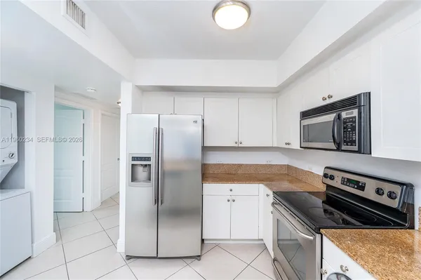 a kitchen with stainless steel appliances granite countertop a refrigerator and a stove top oven