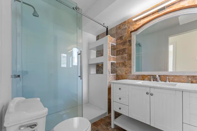 a spacious bedroom with a bed and wooden floor