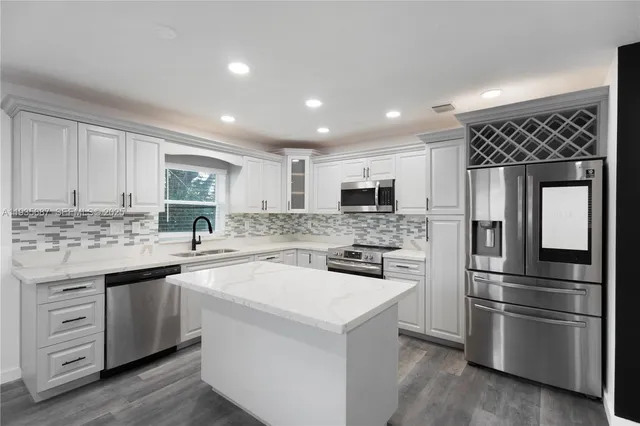 a kitchen with a sink stainless steel appliances and white cabinets