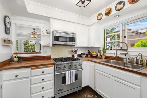 a kitchen with cabinets appliances a sink and a window