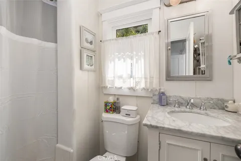 a bathroom with a granite countertop sink toilet and a mirror