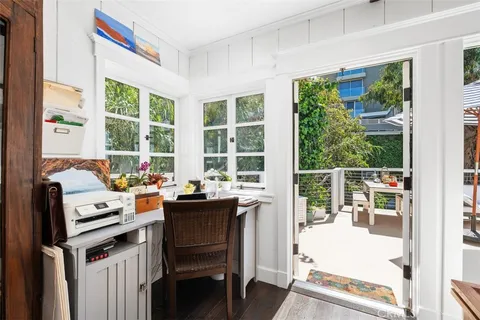 a view of a workspace with furniture and a window
