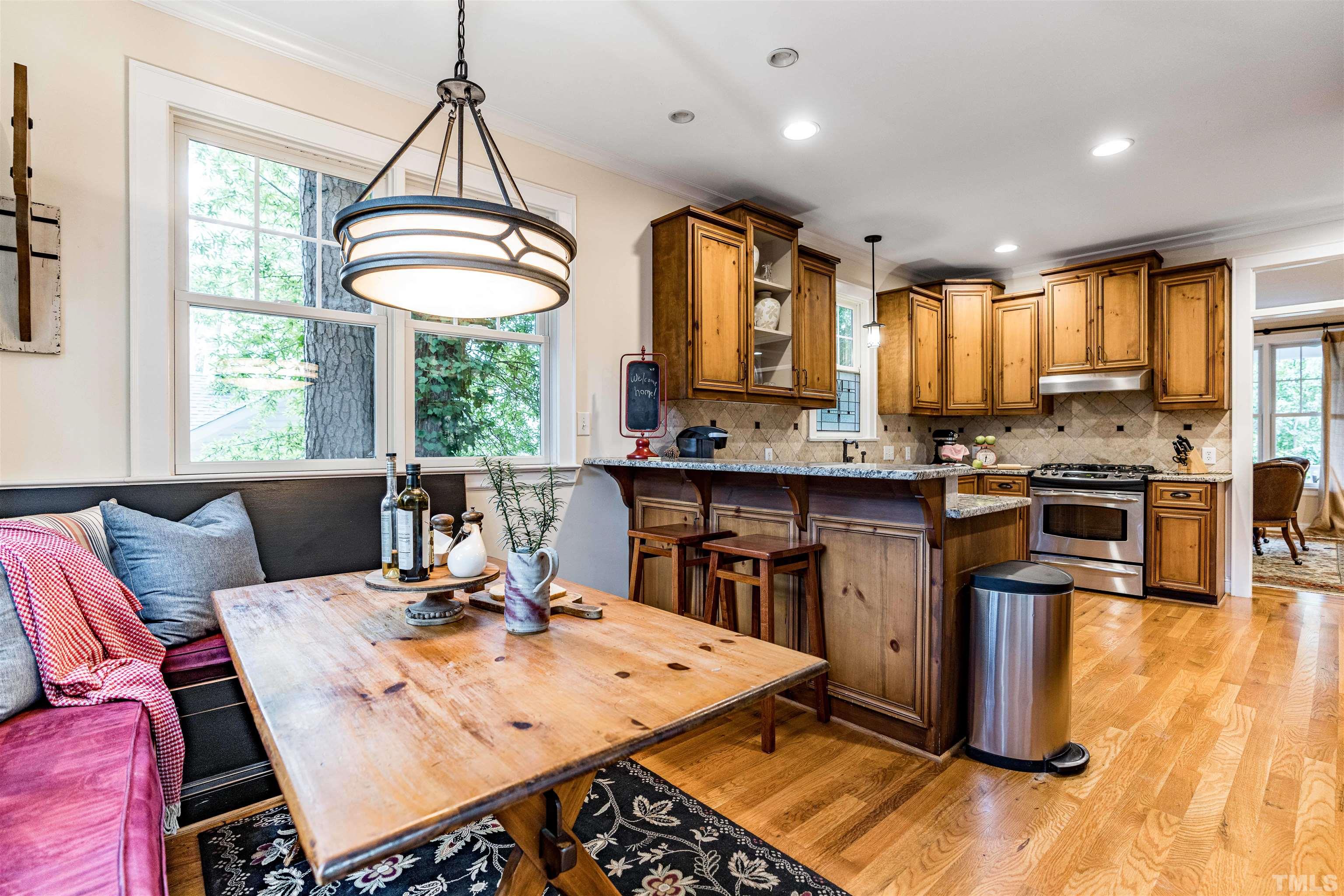 2706 Barmettler Street Raleigh, NC 27607 - Photo 20 of 43 a open kitchen with stainless steel appliances granite countertop a stove top oven a sink dishwasher and white cabinets with wooden floor