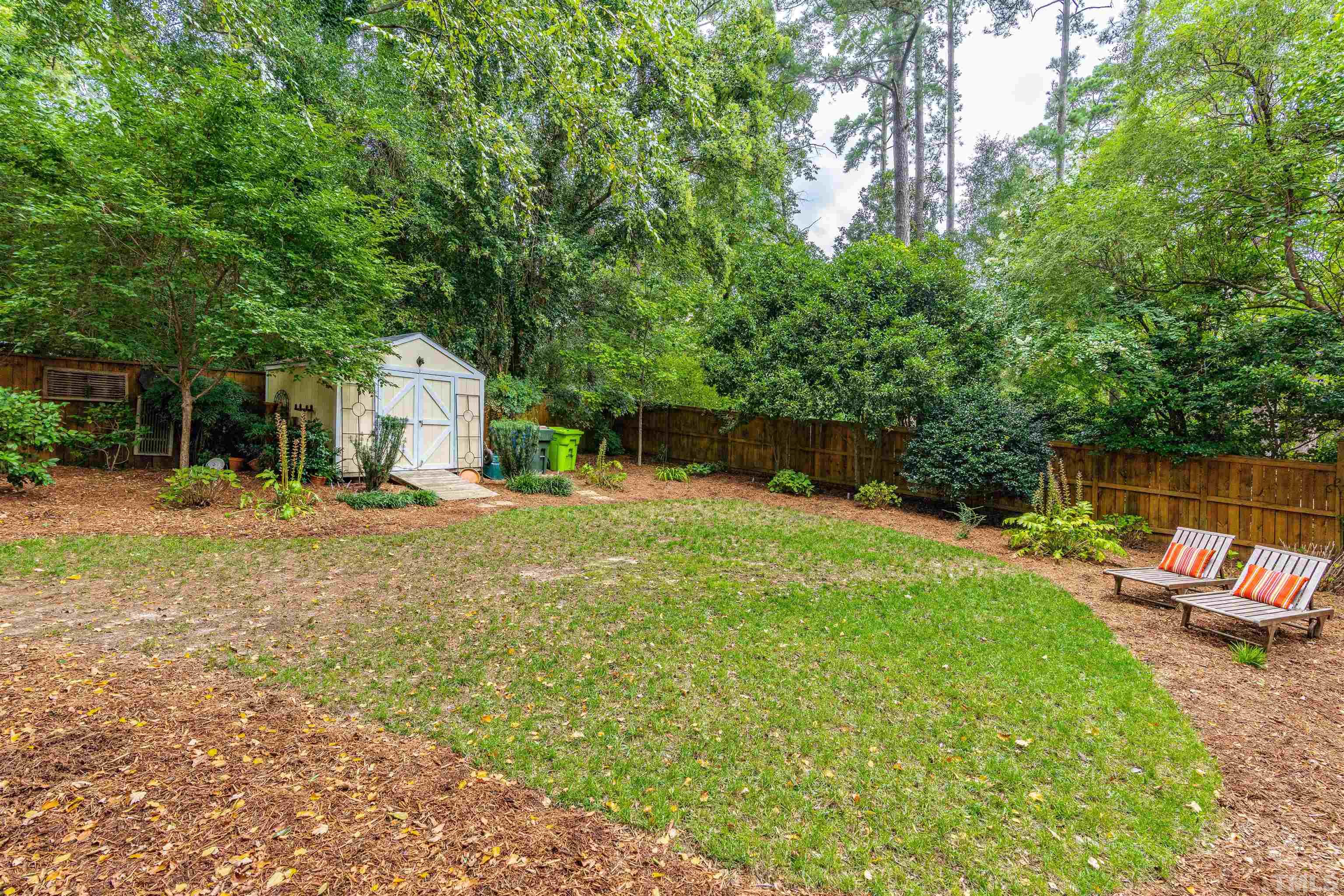 2706 Barmettler Street Raleigh, NC 27607 - Photo 41 of 43 a backyard of a house with table and chairs under an umbrella